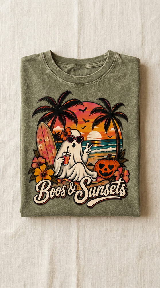 Spooky and fall collection, olive tee with Boos & Sunsets ghost artwork folded on warm linen